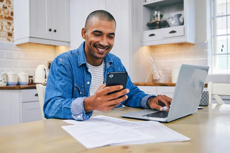 guy in kitchen checking his taxes